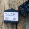 Bar of Palo Santo charcoal soap with packaging on a wooden surface
